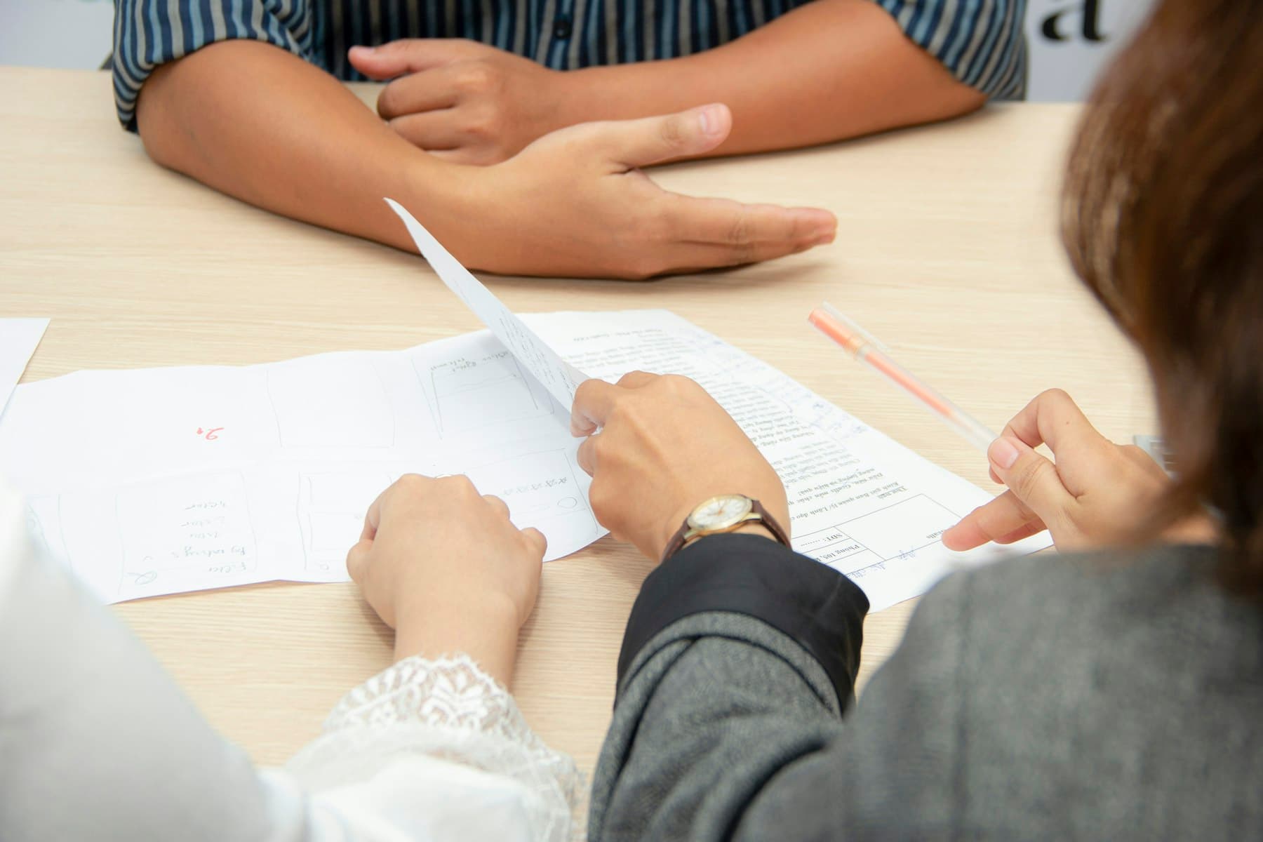 An adviser and an investor reviewing investment paperwork together at a table